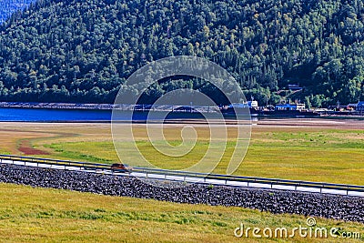 Car driving on a road by lake Tinn, Norway Stock Photo