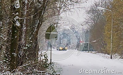 Car driving in winter season on a road fully covered in white snow, slipping risk, cold weather conditions Stock Photo