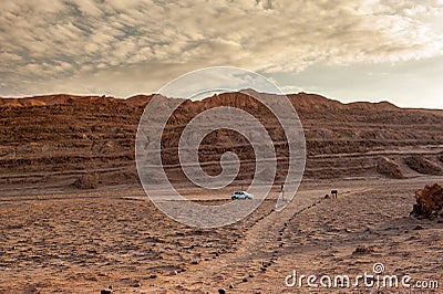 Car on empty parking lot at Valle de la Luna Moon Valley, San Pedro de Atacama Chile. Wide view of stunning sun rise on sand forma Stock Photo