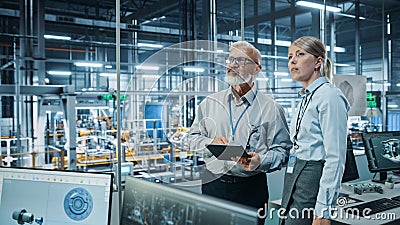 Car Factory: Female Project Manager Talks to Male Automotive Engineer, Plan Strategy Using Tablet Stock Photo