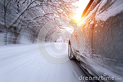 Car and falling snow in winter on forest road with much snow. Stock Photo