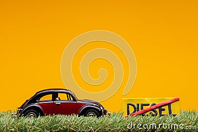 Chisinau 20.02.2020:A car figurine aligned to the left on grass next to a sign which has the word diesel cut Stock Photo
