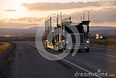 Car hauler semi truck on the road in sunset Stock Photo