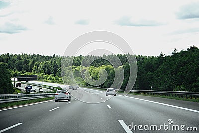 Car on highway amidst green trees Stock Photo