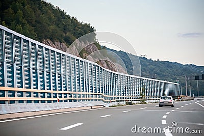 Car on the highway with noise barrier Stock Photo