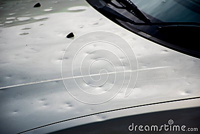 Car hood damaged by major hailstorm hailstones. Car insurance repair dents. Dented car bonnet Stock Photo
