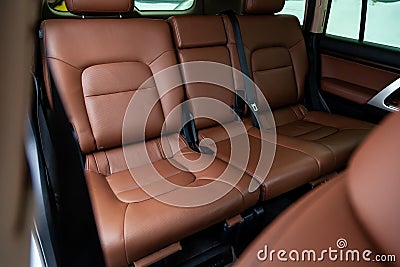 Car inside rear passenger place. Brown interior of prestige modern car. Front seats with steering wheel dashboard. After washing Stock Photo