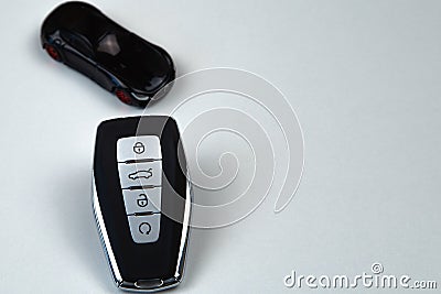 The car keys are black with metal inserts and automatic opening and closing buttons lying on the side on a white Stock Photo