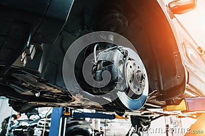 Car on lift in car service with wheels removed for repair and maintenance Stock Photo