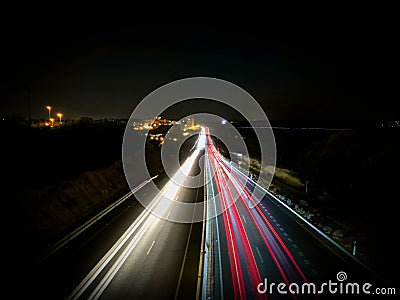 Car lights on a highway and transmission tower at night, long exposure photo of traffic Stock Photo