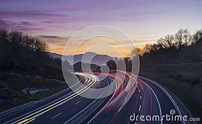 Car lights at night on the road going to the city of Donostia Stock Photo