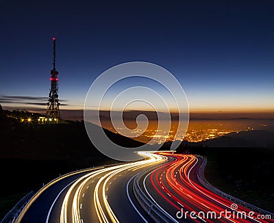 Car lights at night towards the city and communications antenna Editorial Stock Photo