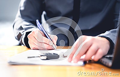 Car loan form or lease application document. Man signing paper contract to sell premium vehicle. Buyer or dealer in agency. Stock Photo