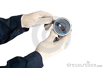 A car locksmith holds a spent old timing belt tensioner roller on a white background, isolate. Timing Belt Roller Replacement Stock Photo