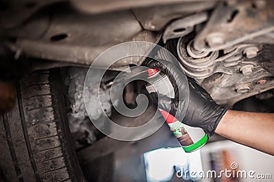 Car master mechanic repairer lubricates screws with machine cleaner spray Stock Photo
