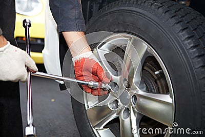Car mechanic changing tire. Stock Photo