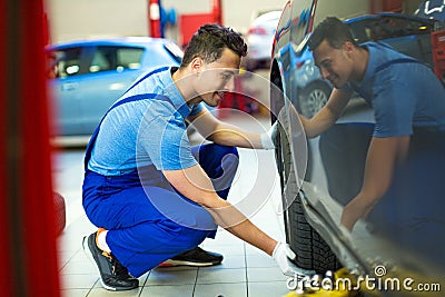 Car mechanic changing tires Stock Photo
