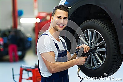 Car mechanic changing tires Stock Photo