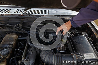 car mechanic is checking condition of engine to make it ready for use and mechanic is still maintaining worn out equipment to Stock Photo