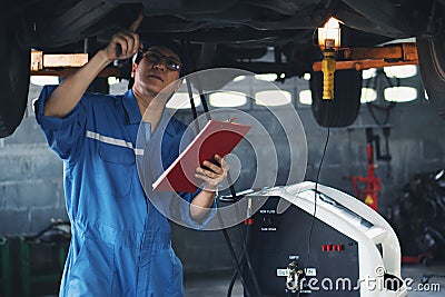 Car mechanic checking and having car transmition maintenance service at garage and service station Stock Photo