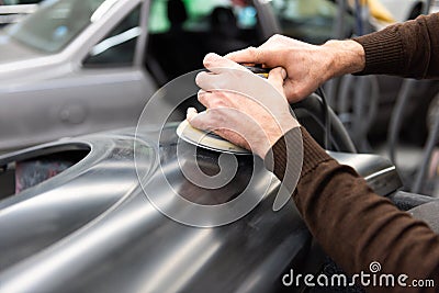 Car mechanic grinds a car part in handicraft in a service station - Serie car repair workshop Stock Photo