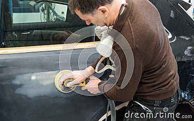 Car mechanic grinds a car part in handicraft in a service station - Serie car repair workshop Stock Photo