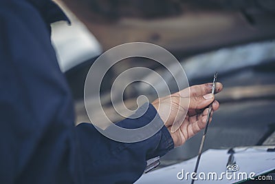 Car Mechanic man hand checking dipstick engine oil car mechanical on site service. Close up hand man check engine oil level Locate Stock Photo