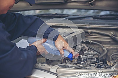 Car Mechanic man hands pouring Deionized purified Distilled water for car battery mechanical service. Close up hands man hold Stock Photo