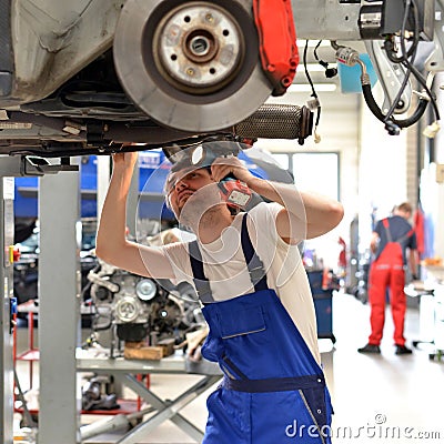 Car mechanic repairs vehicle in a workshop Stock Photo