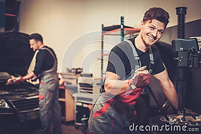 Car mechanic replace tire on wheel in auto repair service. Stock Photo