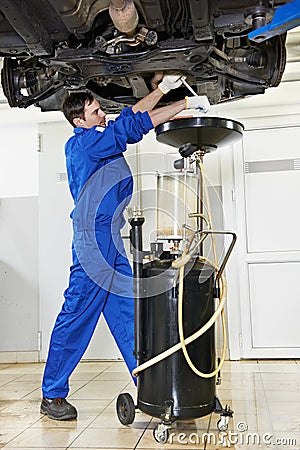 Car mechanic replacing oil from motor engine Stock Photo