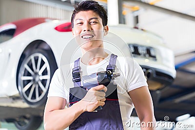 Car mechanic with tool in Asian Chinese auto workshop Stock Photo