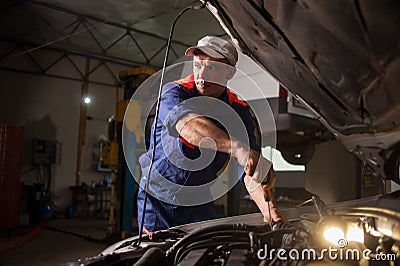 Car mechanic working in auto repair service. Repairing car using Stock Photo