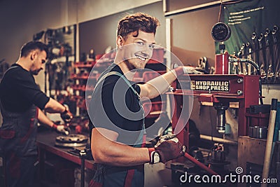 Car mechanic working with hydraulic press in auto repair service. Stock Photo