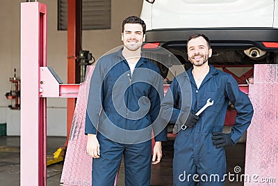 Car Mechanics In Coveralls Standing In Garage Stock Photo