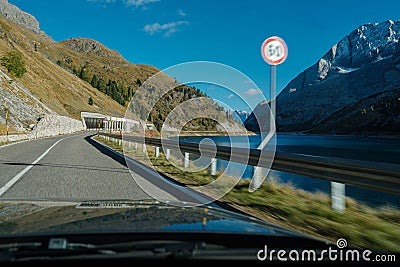 Car moving fast with speed limit violation on a twisty road with a rocky landscape. Stock Photo