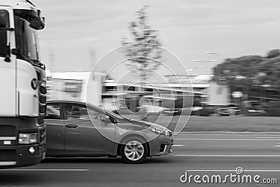 The car overtakes the truck at high speed on the street in heavy traffic. Motion blur. Riga, Latvia - 09 Sep 2021 Editorial Stock Photo