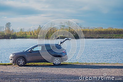 Car is parked in a scenic location by a lake, with the trunk open Editorial Stock Photo