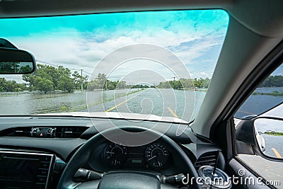 Car parking on a Huge flood highway. white car driving on a flooded road with yellow Road line Stock Photo