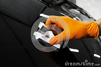 Car polish wax worker hands polishing car. Buffing and polishing vehicle. Car detailing. Man holds a polisher in the hand and poli Stock Photo