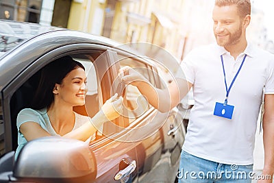 Car rental agency employee giving car keys to woman Stock Photo