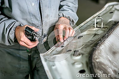 Car repair in car service. Locksmith grinds car detail, hands close-up Stock Photo