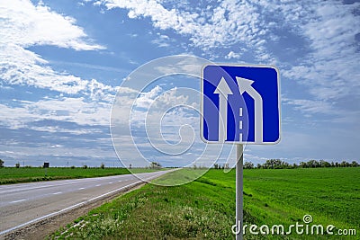 Car road sign `The end of the additional lane on the rise or runaway strip` against a blue sky Stock Photo