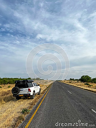 Car at roadside parked in savannah. White SUV off road vehicle. Toyota Hilux. Editorial Stock Photo