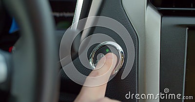 Car`s ignition button is getting pushed to start and stop the vehicle. pushing power ignition button to start keyless Stock Photo