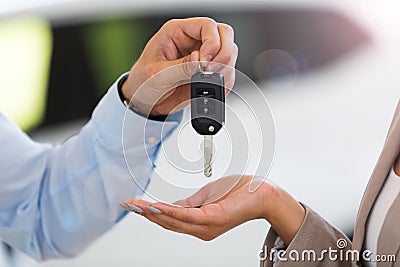 Car salesman handing car keys to woman Stock Photo