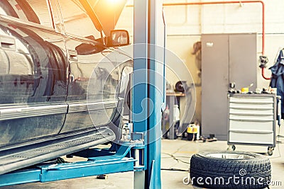 Car service center. Old rusty offroad SUV vehicle raised on lift at maintenance station. Automobile repair and check up. Stock Photo