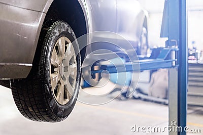 Car at service center. Vehicle raised on a lift. Check up, maintenance and repair concept Stock Photo