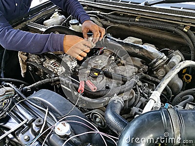 Car service engine, repair, check up maintenance, auto mechanic man tightened valve under hood car, people hand fixing car engine Stock Photo