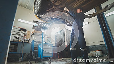 Car service - a mechanic checks the suspension of car, wide angle Stock Photo